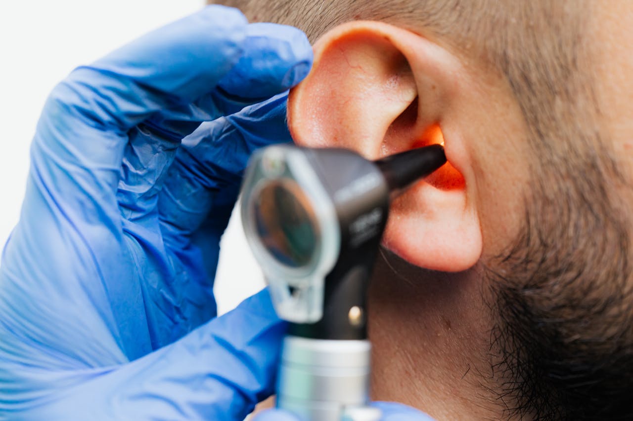 about-us Close-up of a doctor using an otoscope to examine a patient's ear in a clinical setting.