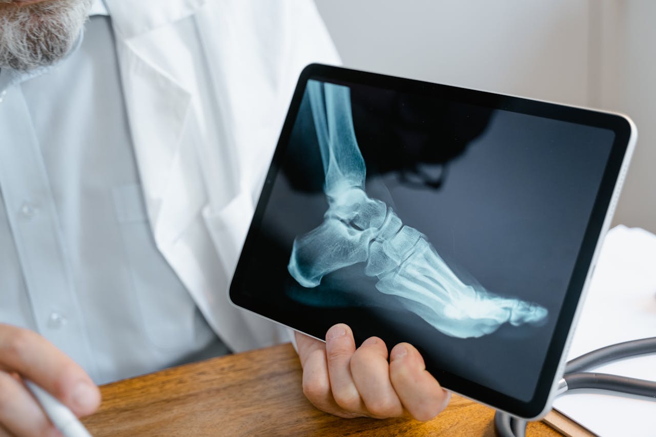 our-story A doctor examines an x-ray image of a foot displayed on a tablet.
